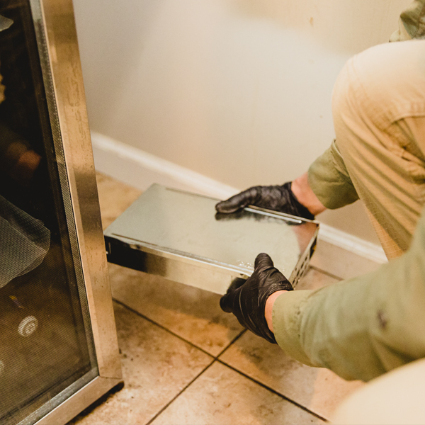 A pest control company tech placing a rat trap